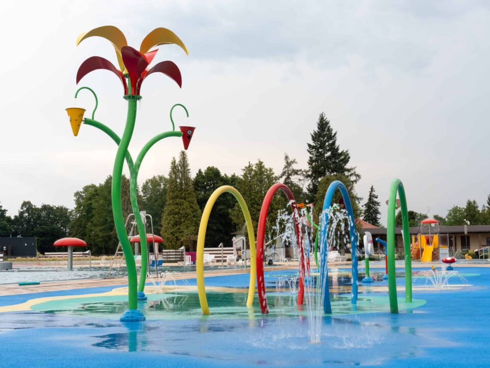 Vibrant outdoor water playground featuring colorful sprinklers and play structures, perfect for summer fun and family activities. High quality photo